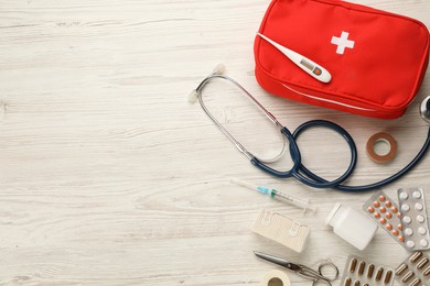 Photo of First aid kit on white wooden table, flat lay. Space for text