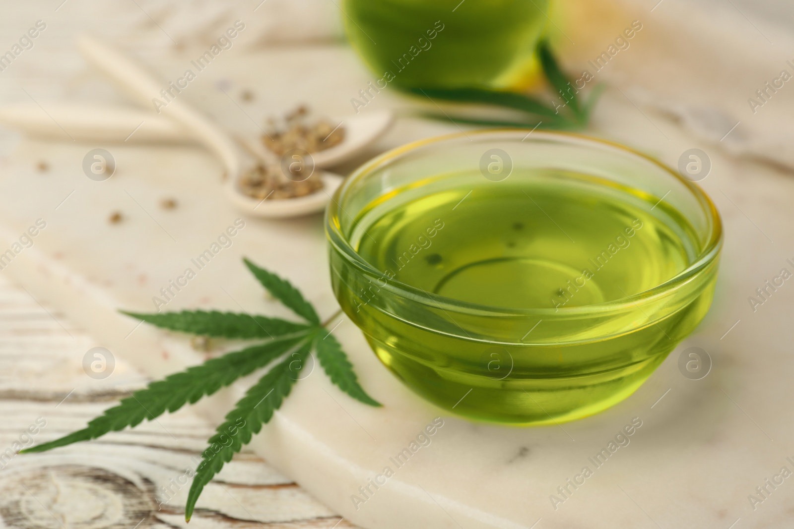 Photo of Glass bowl with hemp oil on table, closeup