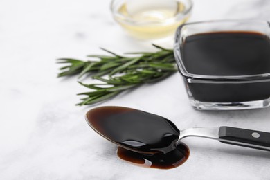 Photo of Organic balsamic vinegar and cooking ingredients on white table, closeup