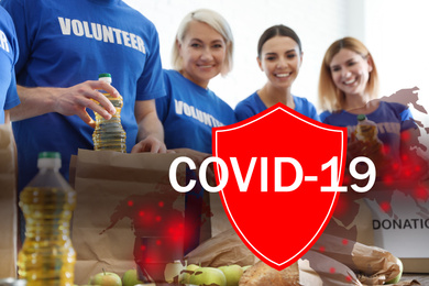Image of Volunteers uniting to help during COVID-19 outbreak. Group of people collecting food donations at table, shield and world map illustrations