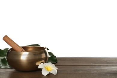 Photo of Golden singing bowl, mallet and flower on wooden table against white background, space for text