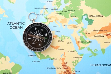 One compass on world map, top view. Space for text