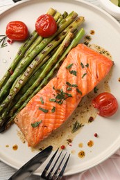 Photo of Tasty grilled salmon with tomatoes, asparagus and spices served on table, top view