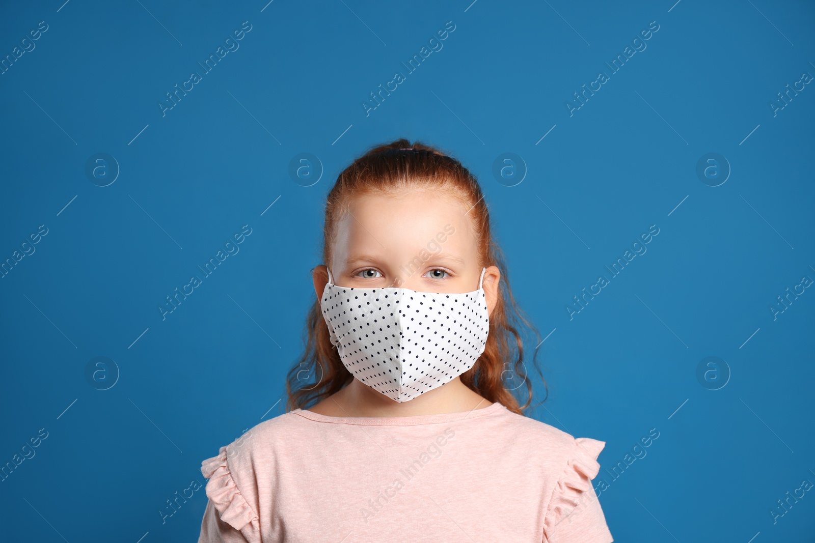 Photo of Preteen girl in protective face mask on blue background