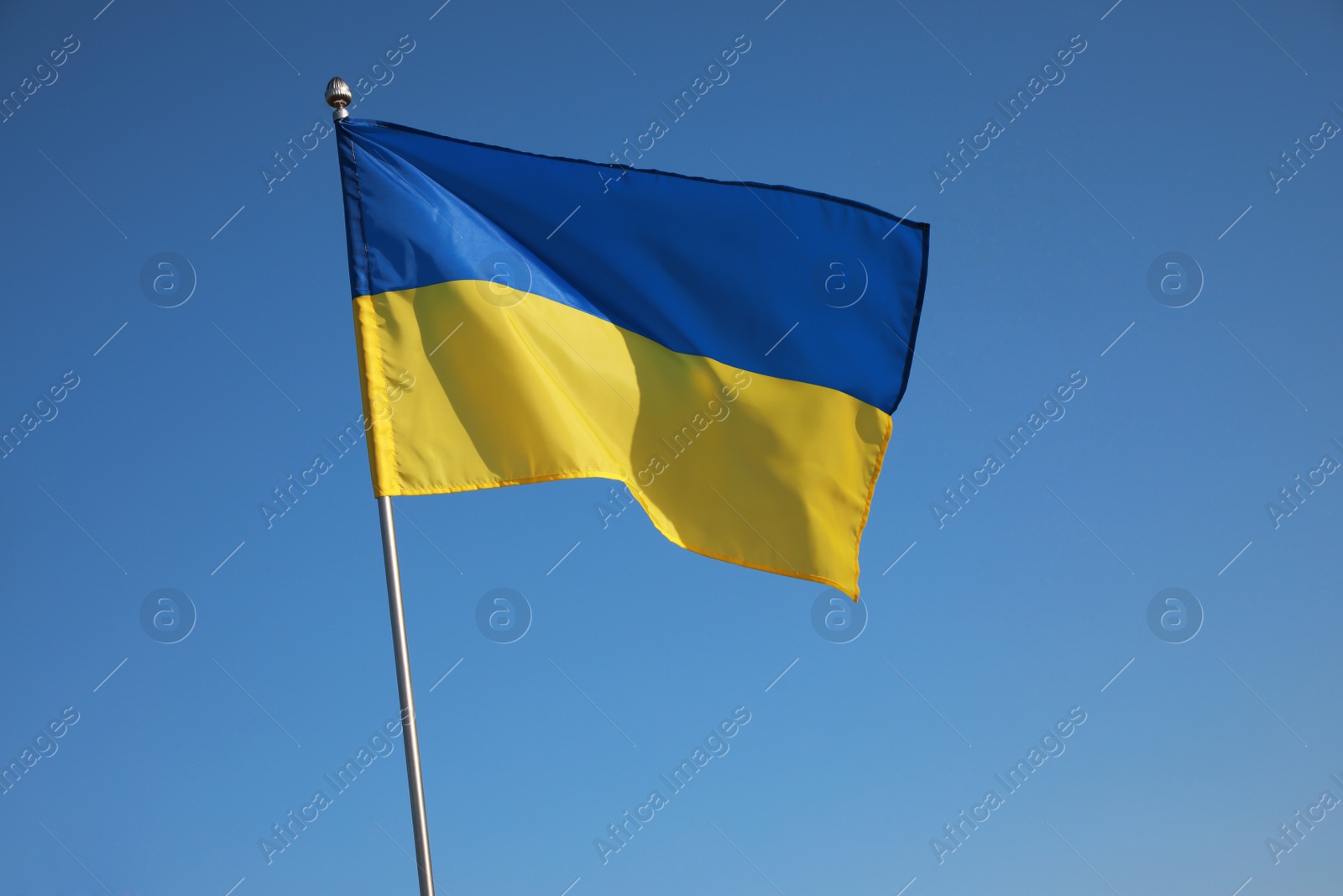 Photo of National flag of Ukraine against blue sky