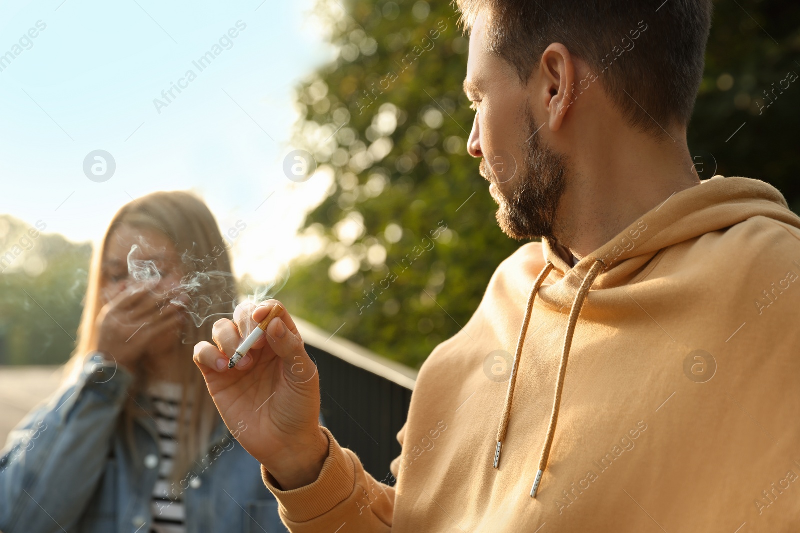 Photo of Handsome man smoking cigarette at public place outdoors