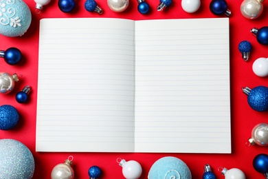 Flat lay composition with empty notebook and Christmas decorations on red background, space for text. Writing letter to Santa Claus