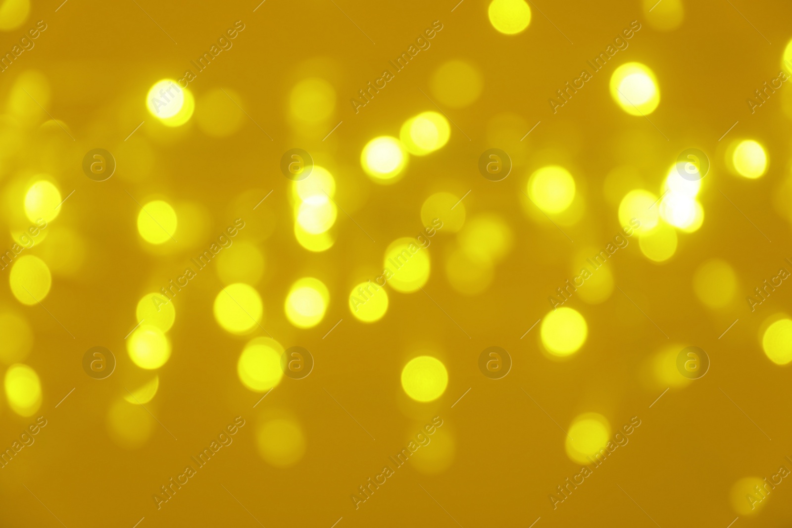 Photo of Blurred view of shiny gold lights. Bokeh effect