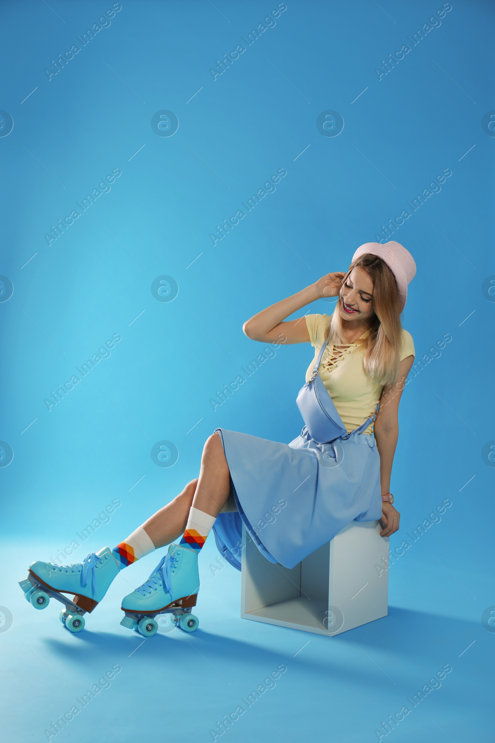 Photo of Young woman with retro roller skates on color background