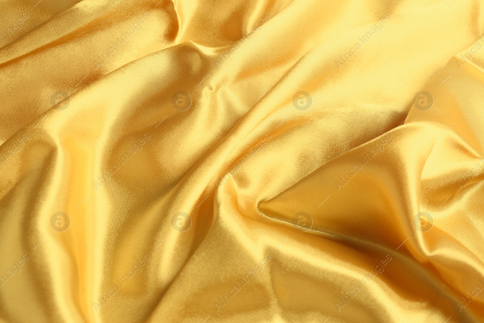 Photo of Golden shiny fabric as background, top view