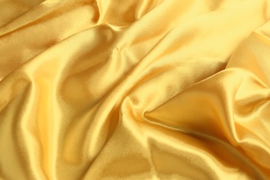 Photo of Golden shiny fabric as background, top view
