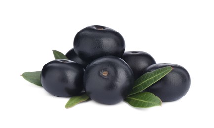 Pile of fresh ripe acai berries and green leaves on white background