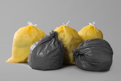 Trash bags full of garbage on grey background