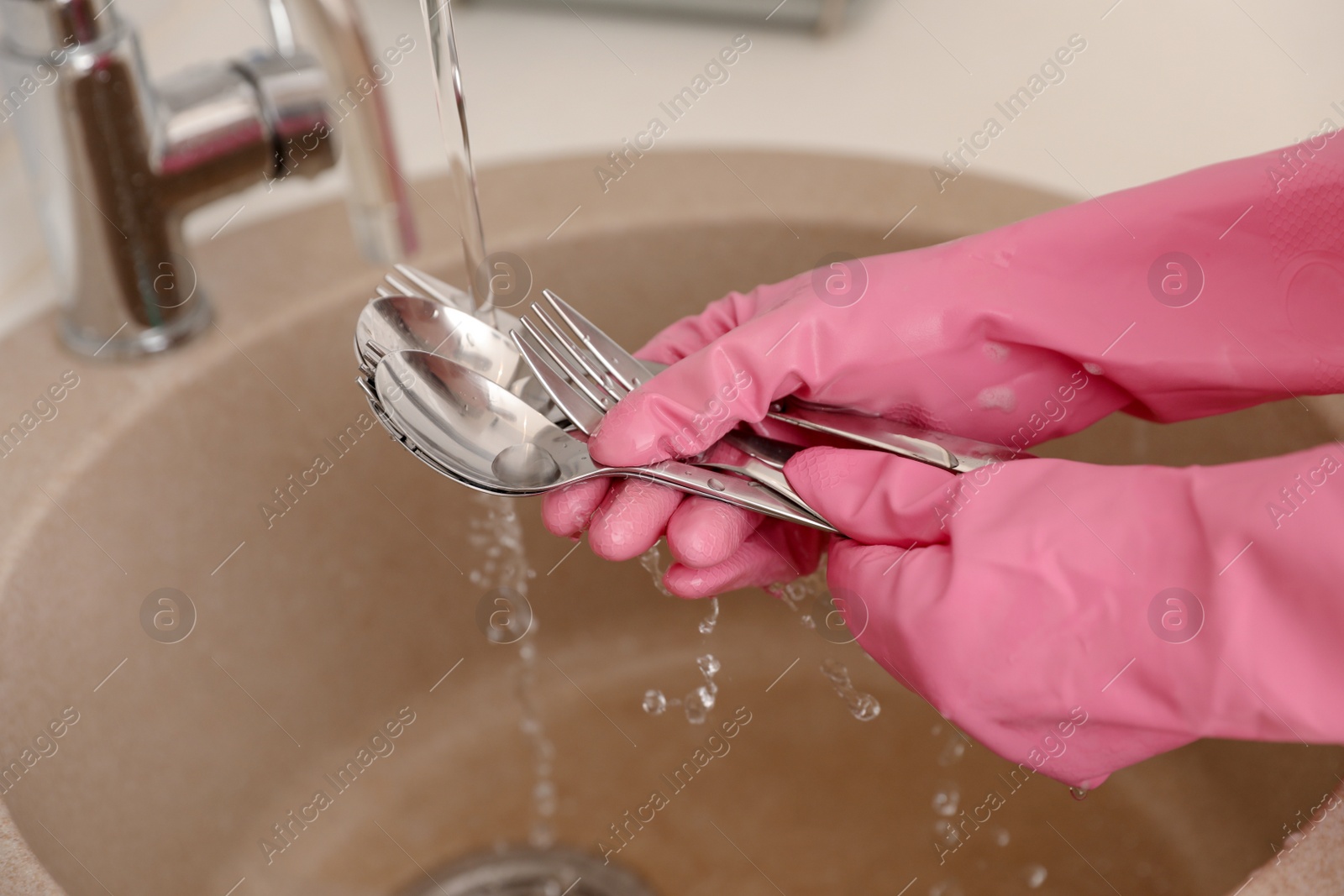 Photo of Woman doing washing up in kitchen sink, closeup view. Cleaning chores