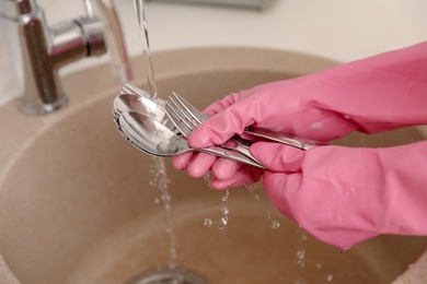 Woman doing washing up in kitchen sink, closeup view. Cleaning chores