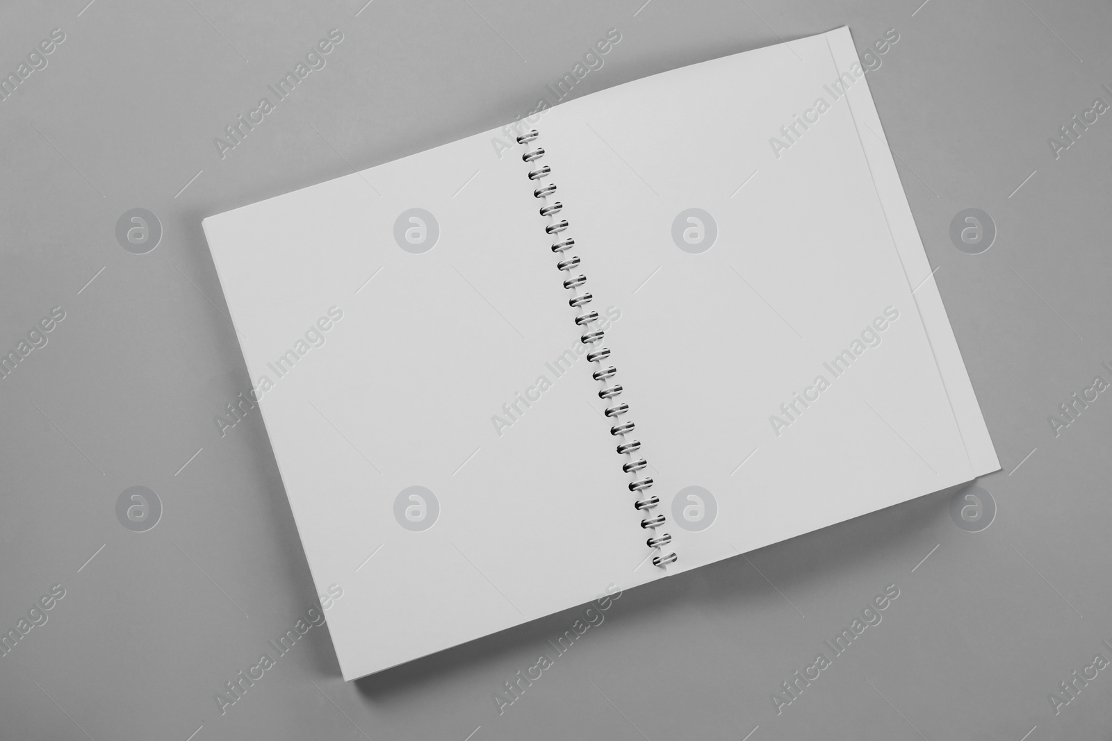 Photo of Open blank notebook on grey background, top view. Mockup for design