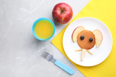 Photo of Tasty pancake served with apple and juice on marble table, flat lay. Creative idea for kids breakfast