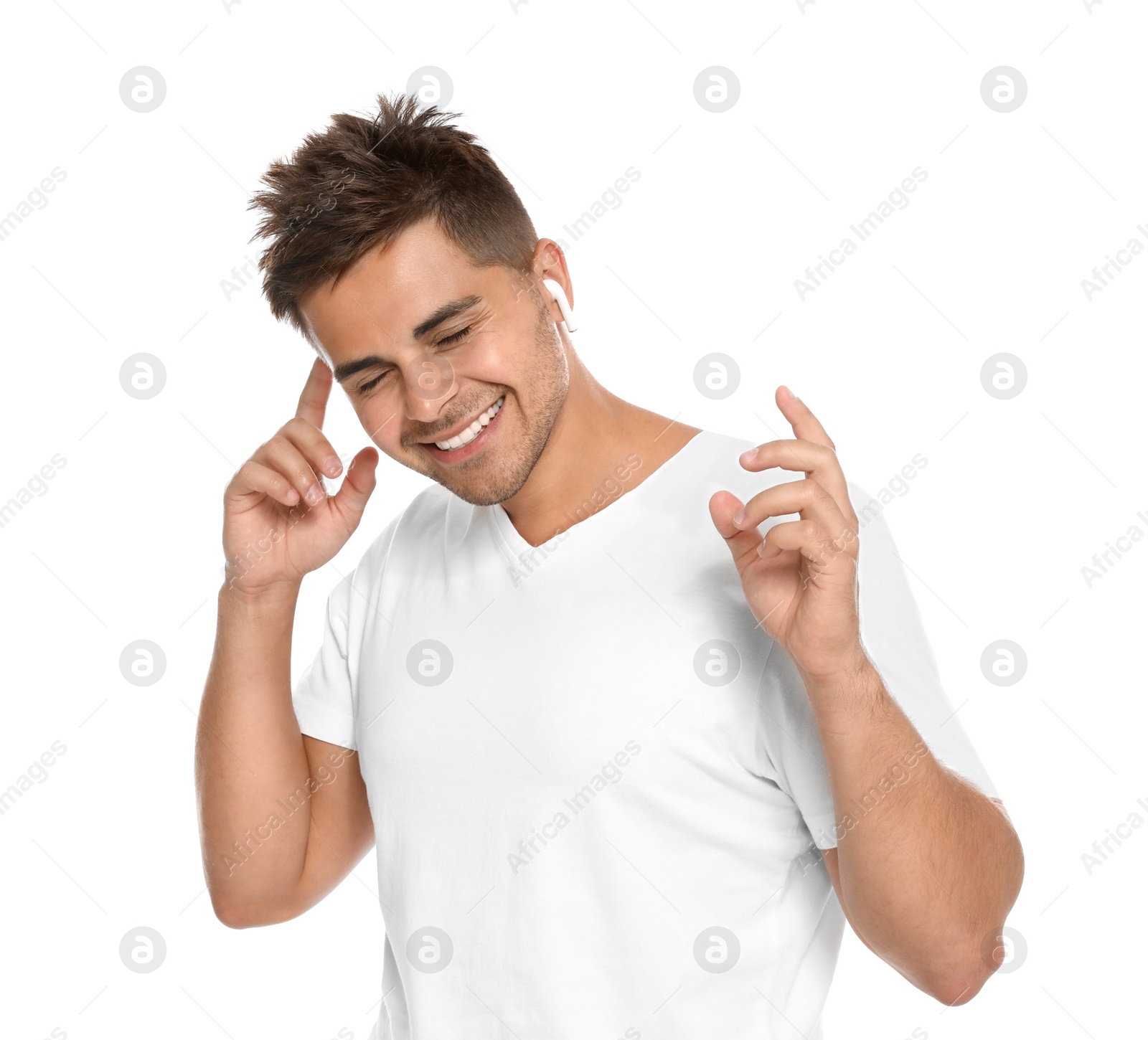 Photo of Happy young man listening to music through wireless earphones on white background