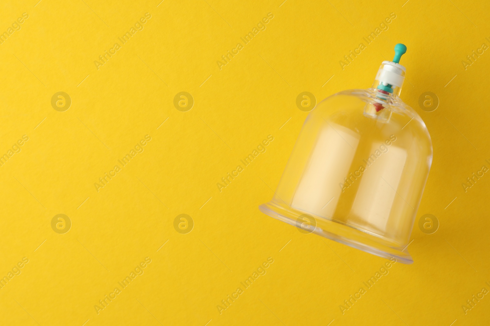 Photo of Plastic cup on yellow background, top view with space for text. Cupping therapy