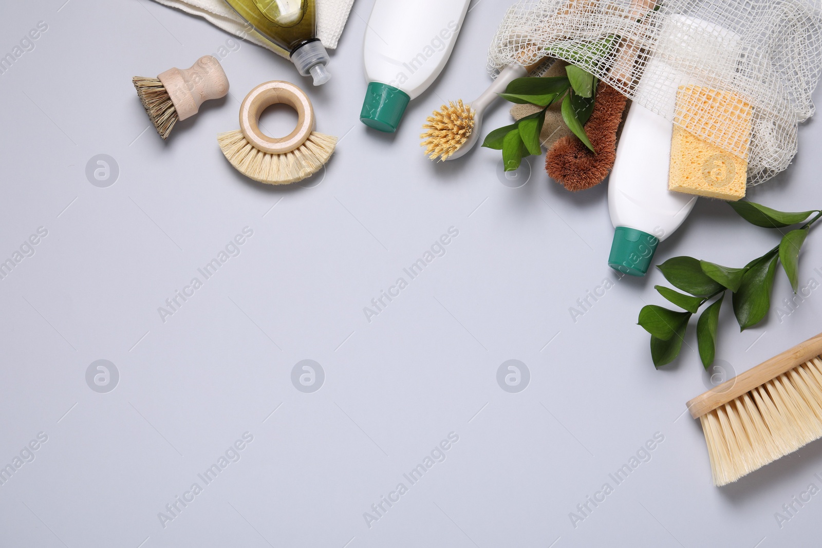 Photo of Flat lay composition with different cleaning supplies on light gray background, space for text