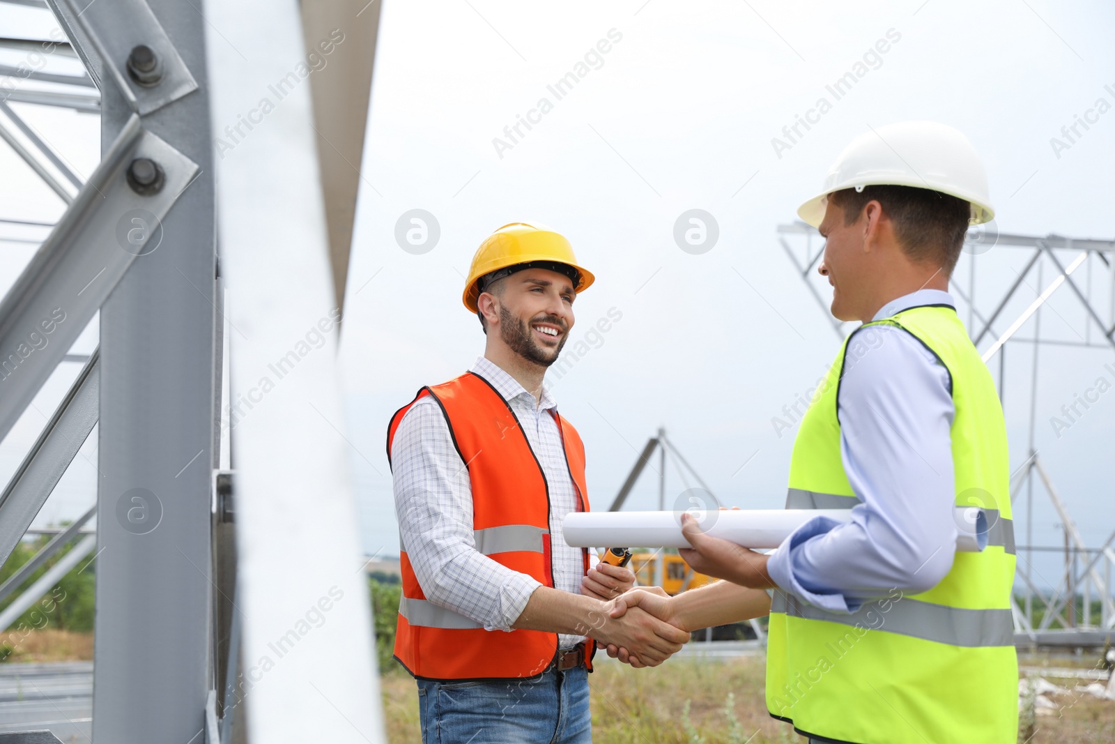 Photo of Professional engineers working on installation of electrical substation outdoors