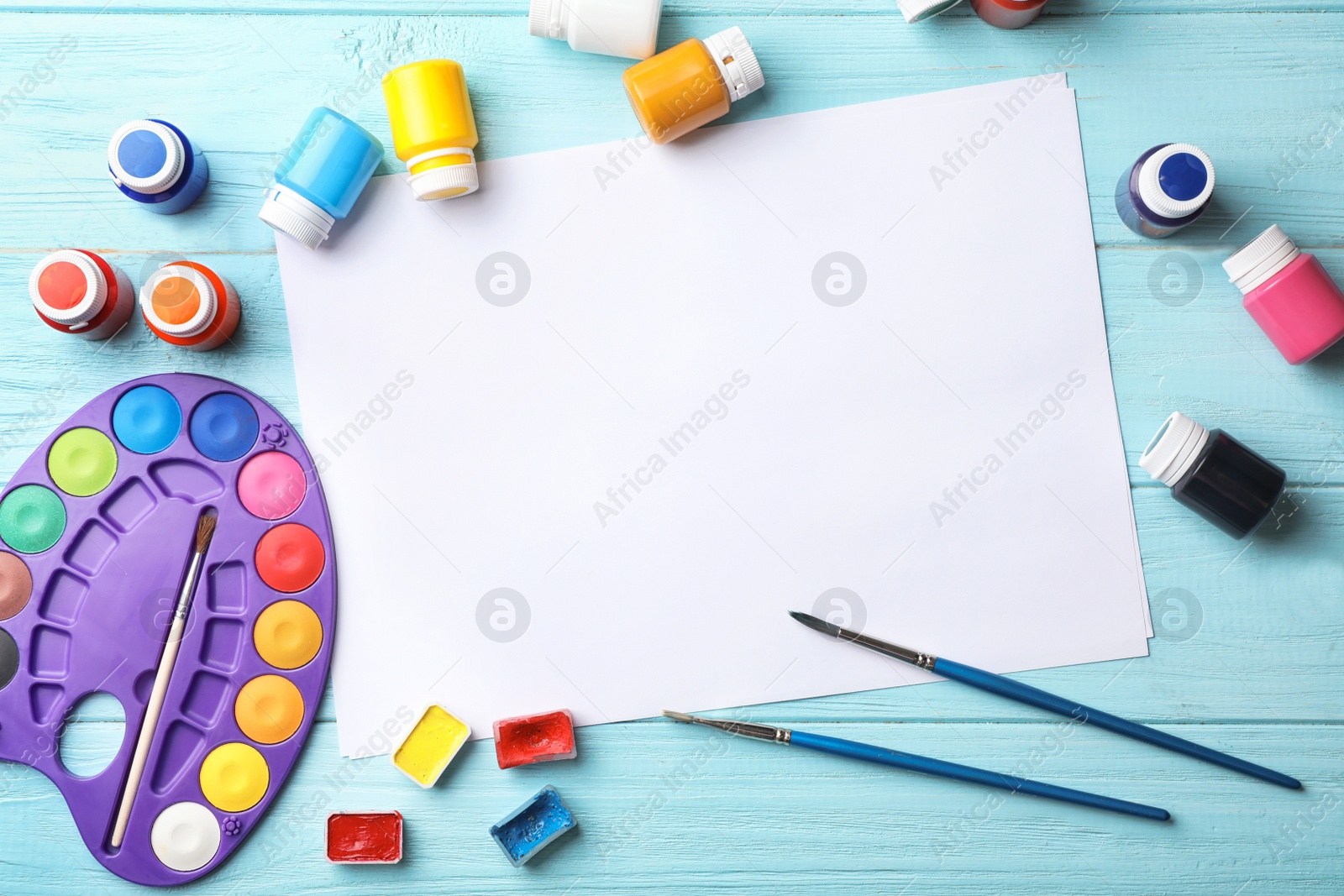 Photo of Flat lay composition with empty paper and painting supplies for child on table. Space for text