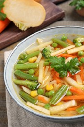 Photo of Bowl of delicious turnip soup on table, closeup