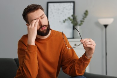 Photo of Overwhelmed man with glasses suffering at home