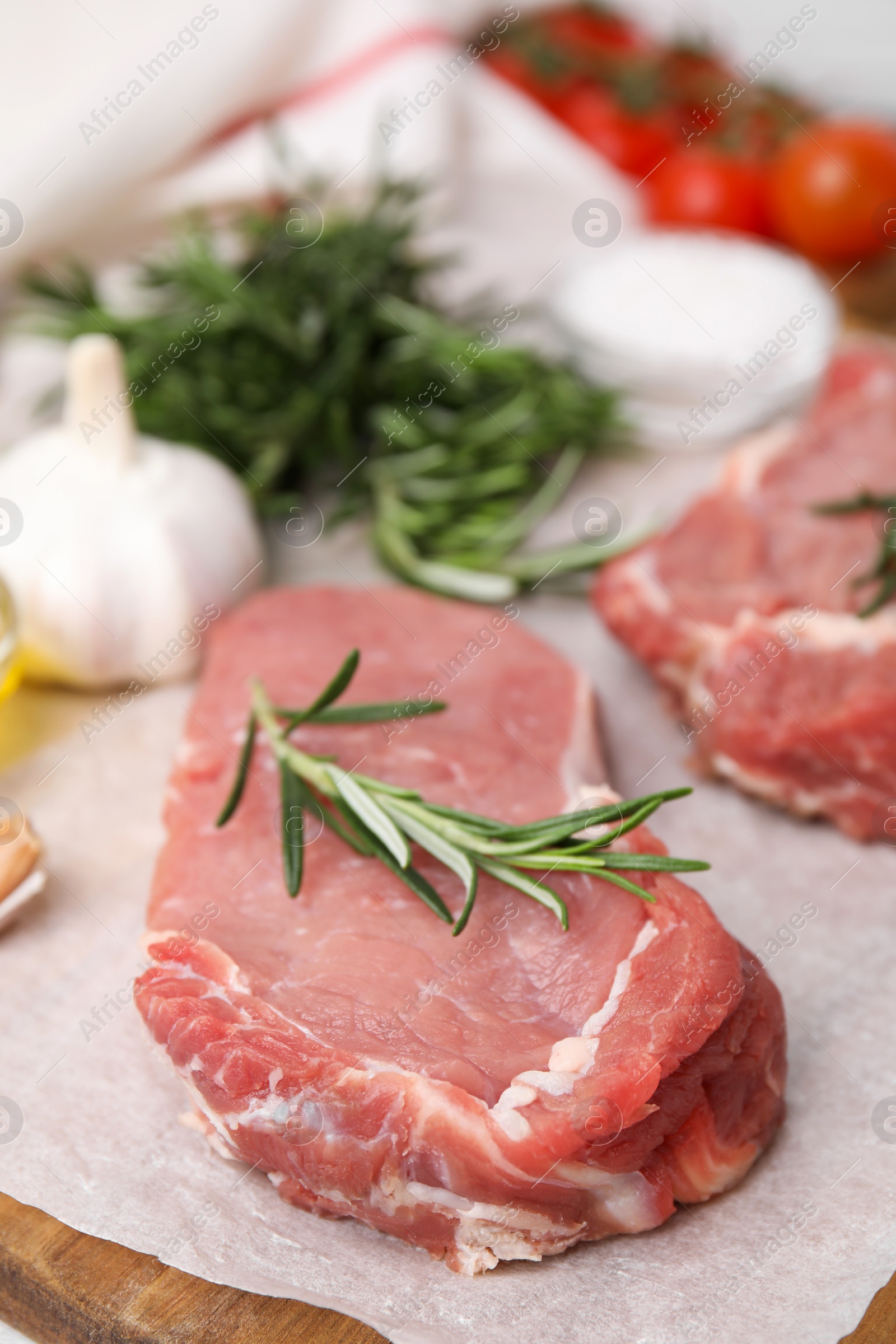 Photo of Fresh raw meat with rosemary on wooden board, closeup