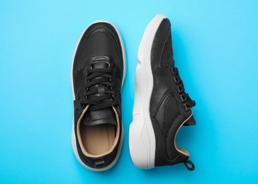 Photo of Pair of stylish shoes on blue background, top view