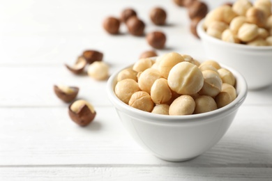 Photo of Bowl with shelled organic Macadamia nuts on white table