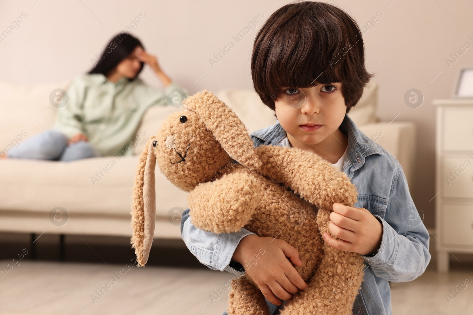 Photo of Upset child with toy bunny at home