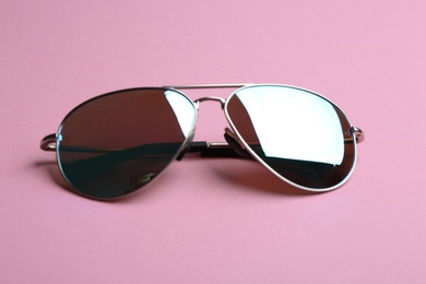 Stylish sunglasses on pink background. Fashionable accessory