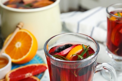 Photo of Tasty mulled wine with spices on table, closeup