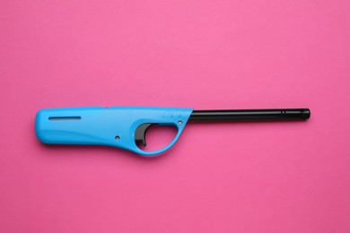 Photo of One gas lighter on pink background, top view