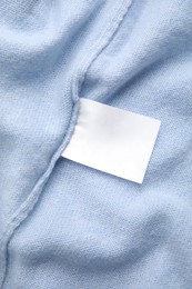 Photo of Warm light blue cashmere sweater with clothing label, closeup