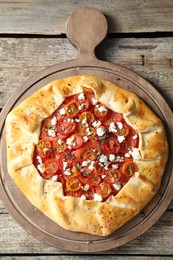 Photo of Tasty galette with tomato, thyme and cheese (Caprese galette) on wooden table, top view