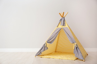Photo of Play tent for kids near white wall with space for text