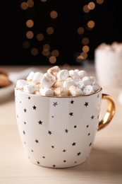 Photo of Cup of hot drink with marshmallows on wooden table