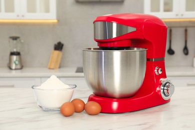 Photo of Modern red stand mixer, eggs and bowl with flour on white marble table in kitchen