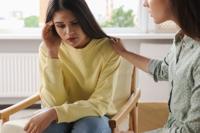 Photo of Professional psychologist working with young woman in office