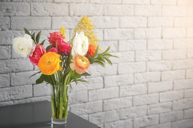 Photo of Vase with beautiful ranunculus flowers indoors