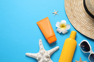 Photo of Flat lay composition with sun protection products on blue background. Space for text