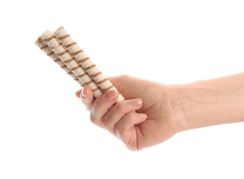 Photo of Woman holding tasty wafer roll sticks on white background, closeup. Crispy food