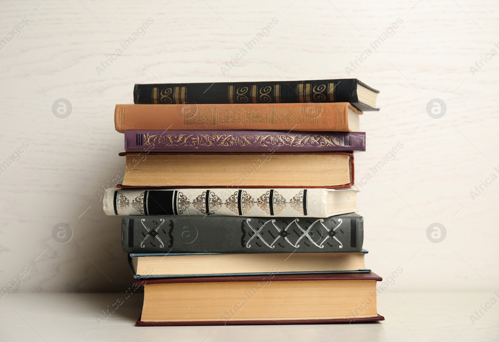 Photo of Collection of different books on table against white wooden background