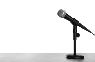 Photo of Modern microphone on table against white background. Space for text