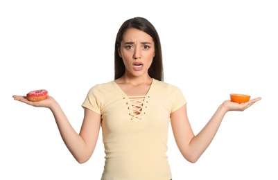 Photo of Woman choosing between orange and doughnut on white background