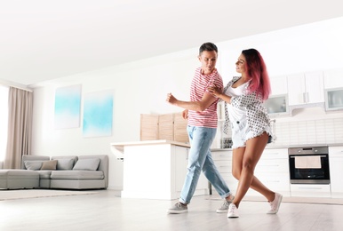 Photo of Beautiful happy couple dancing in room at home