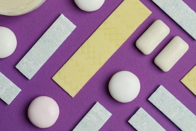 Photo of Different tasty colorful bubble gums on purple background, flat lay