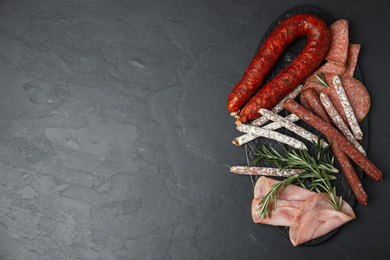 Photo of Different tasty sausages on black table, flat lay. Space for text
